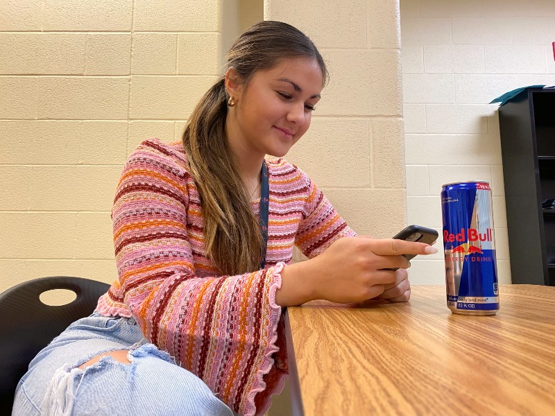 Senior Avery Eckert sits with a Red Bull energy drink. Red Bulls contain 148 mg of caffeine per 16 fl. oz. serving.