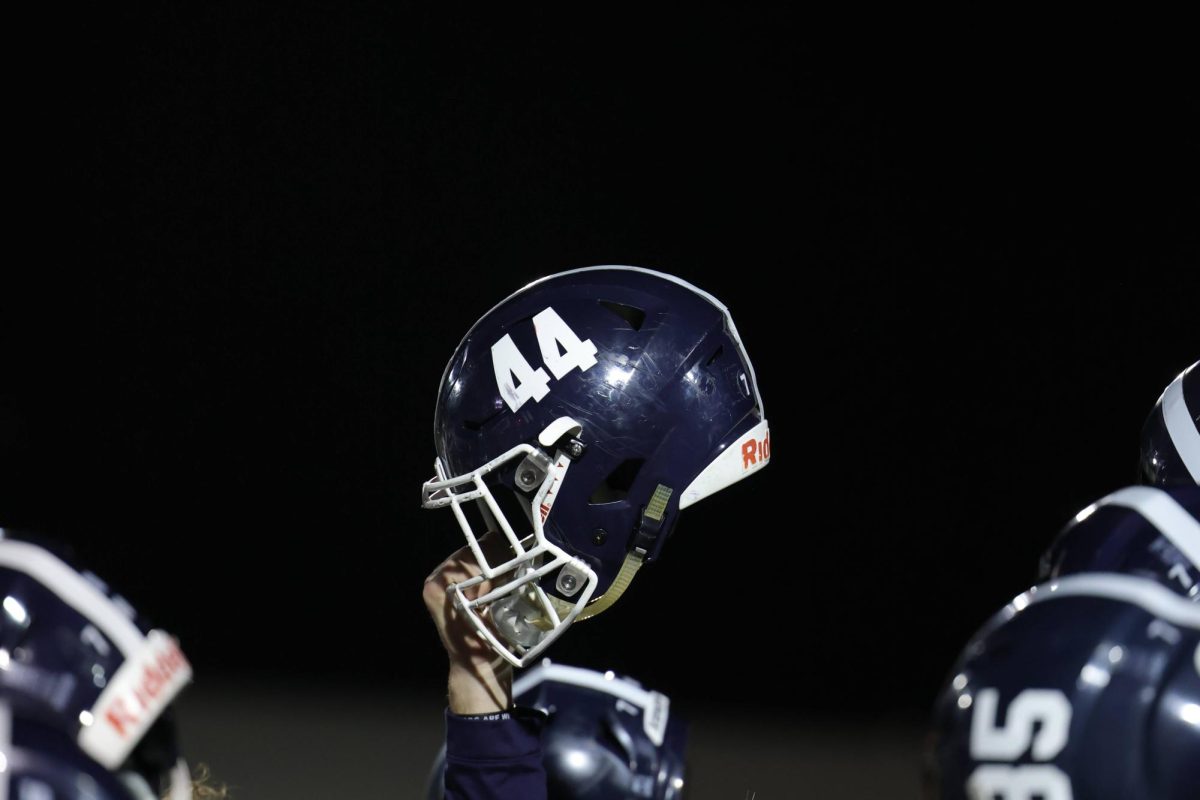 After footballs 54-17 win against Seguin, then junior Davis Kuhn holds his helmet up for the playing of the schools alma mater.