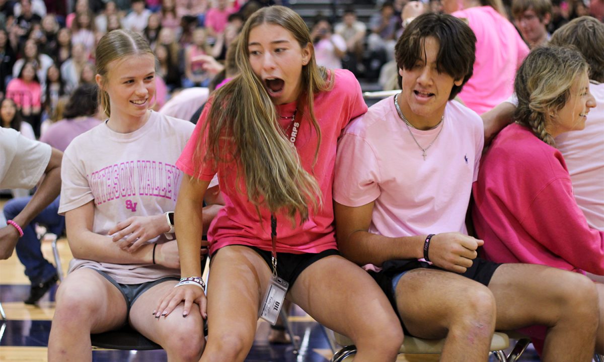 Senior Kaela Stevens fights for a chair during the game of musical chairs at the pink out pep rally.