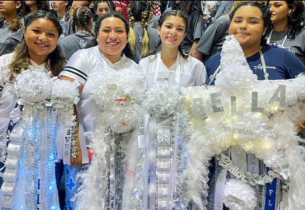 During the homecoming pep rally color guard seniors, Gabrielle Melendez, Hailey Rodriguez, Olivia Diaz, and Bella Munoz pose for a picture showing off their mums.