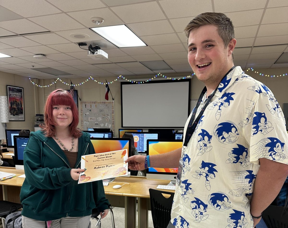Senior Austin Ison hands junior Aubree Pipkin her certificate for placing second in the Papa Johns Slice of Art contest.