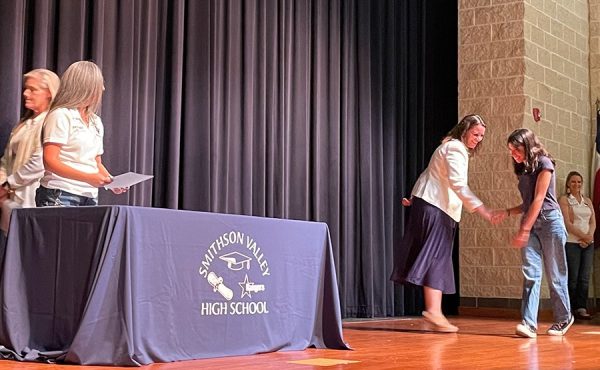 Giving out the annual National Merit recognition awards on October 27th, principal Stacia Snyder shakes hands with junior Madilyn Trevino