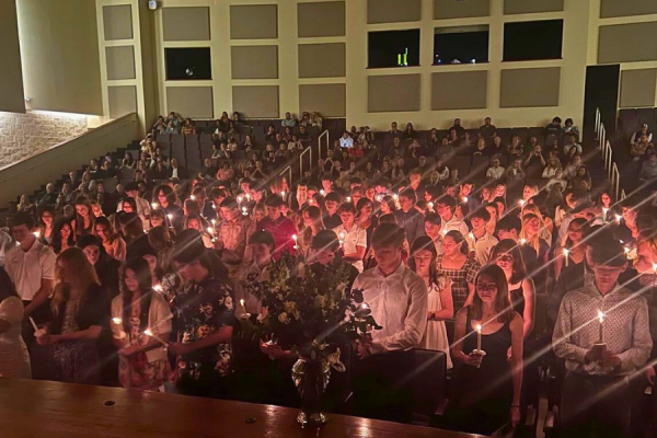 New members hold up candles to signify their induction into the National Honor Society. Photo via NHS Instagram