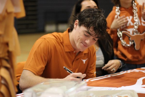 Senior Jackson Duffey signs his letter of intent with the University of Texas at Austin on Feb. 7.