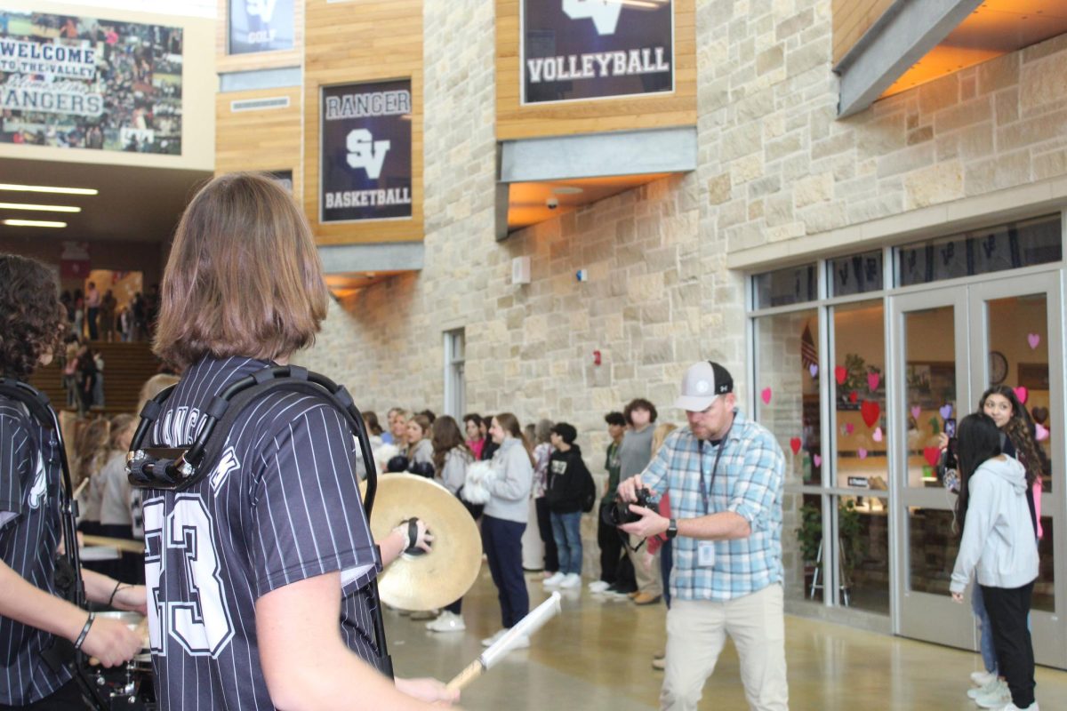 Comal ISD videographer takes videos of drumline playing at the send off.