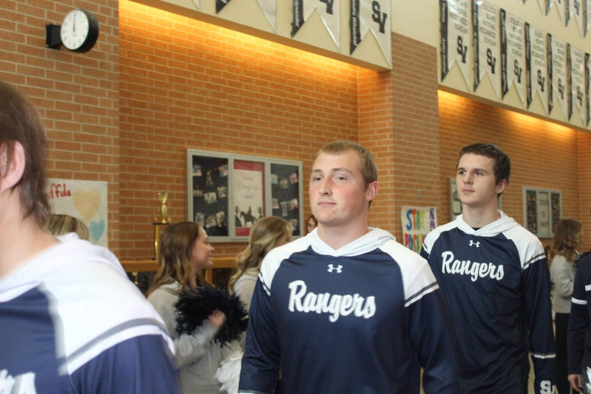 Seniors Dylan Gass and Nick Dudzikowski walk through the main hallway during the wrestling state send off on Feb. 14.