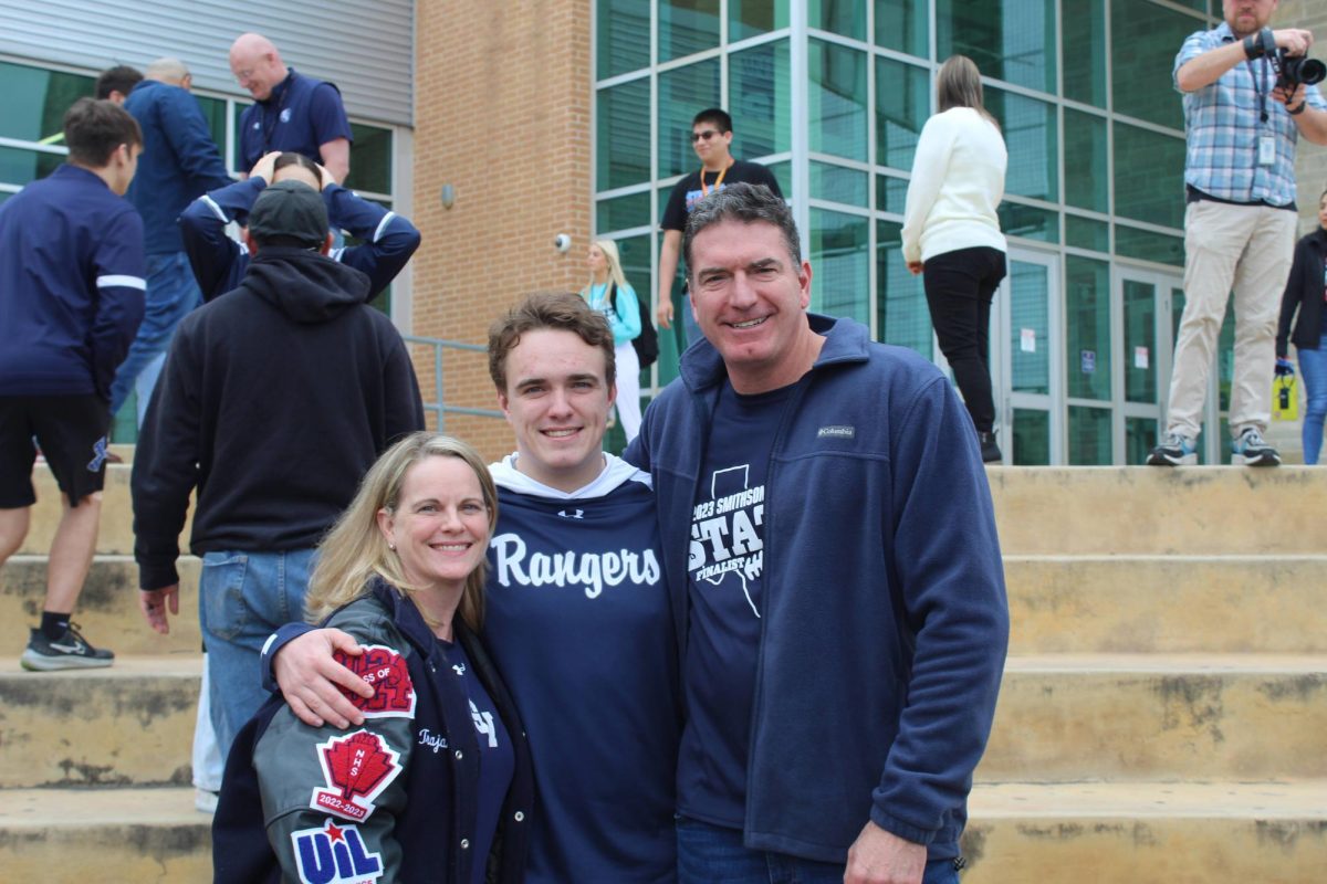 Senior Trajan Falk poses for a photo with his parents. Falk will compete in the 285 weight class at state.