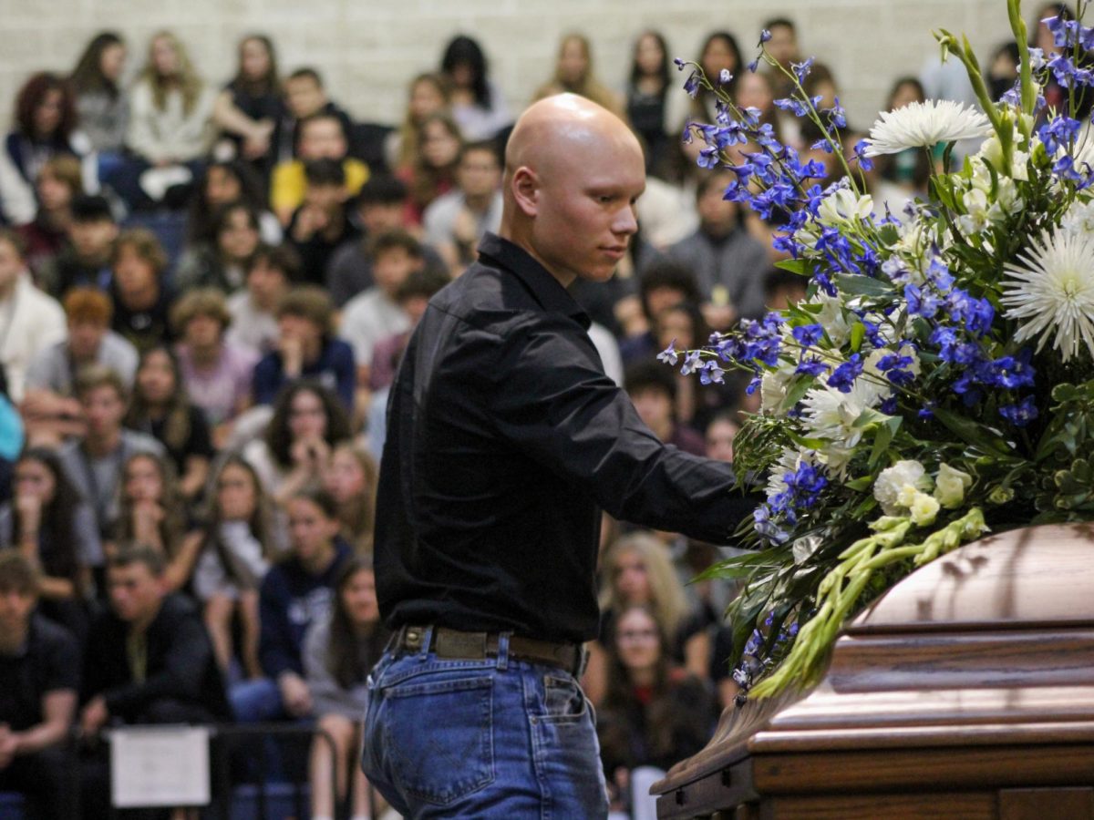 Senior Ryland Walker places a flower on Senior Maverick Ministers casket at the Shattered Dreams March 8. All the broken hearted placed a flower to honor the departed.