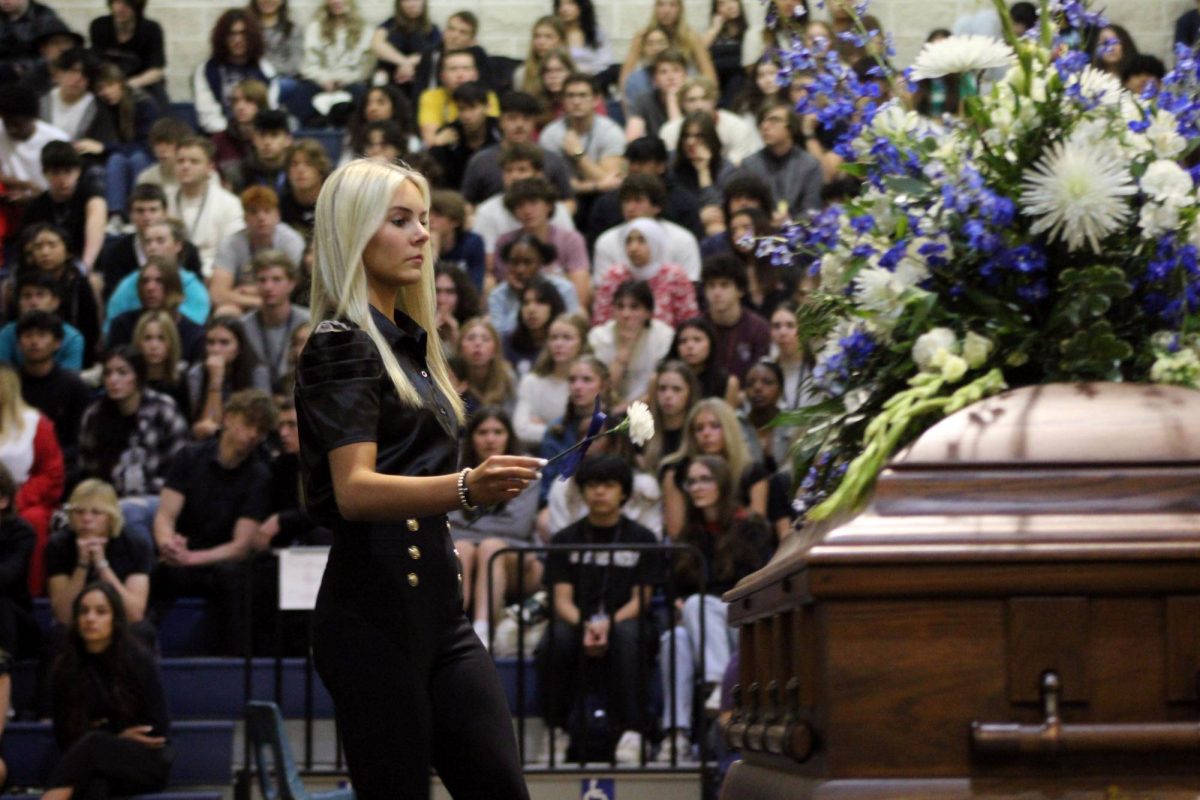 Junior Linkynn Lunsford places a flower on the casket at the mock funeral March 8 to honor her departed friend. Lunsford represented a broken hearted friend her read a eulogy for the student who departed.