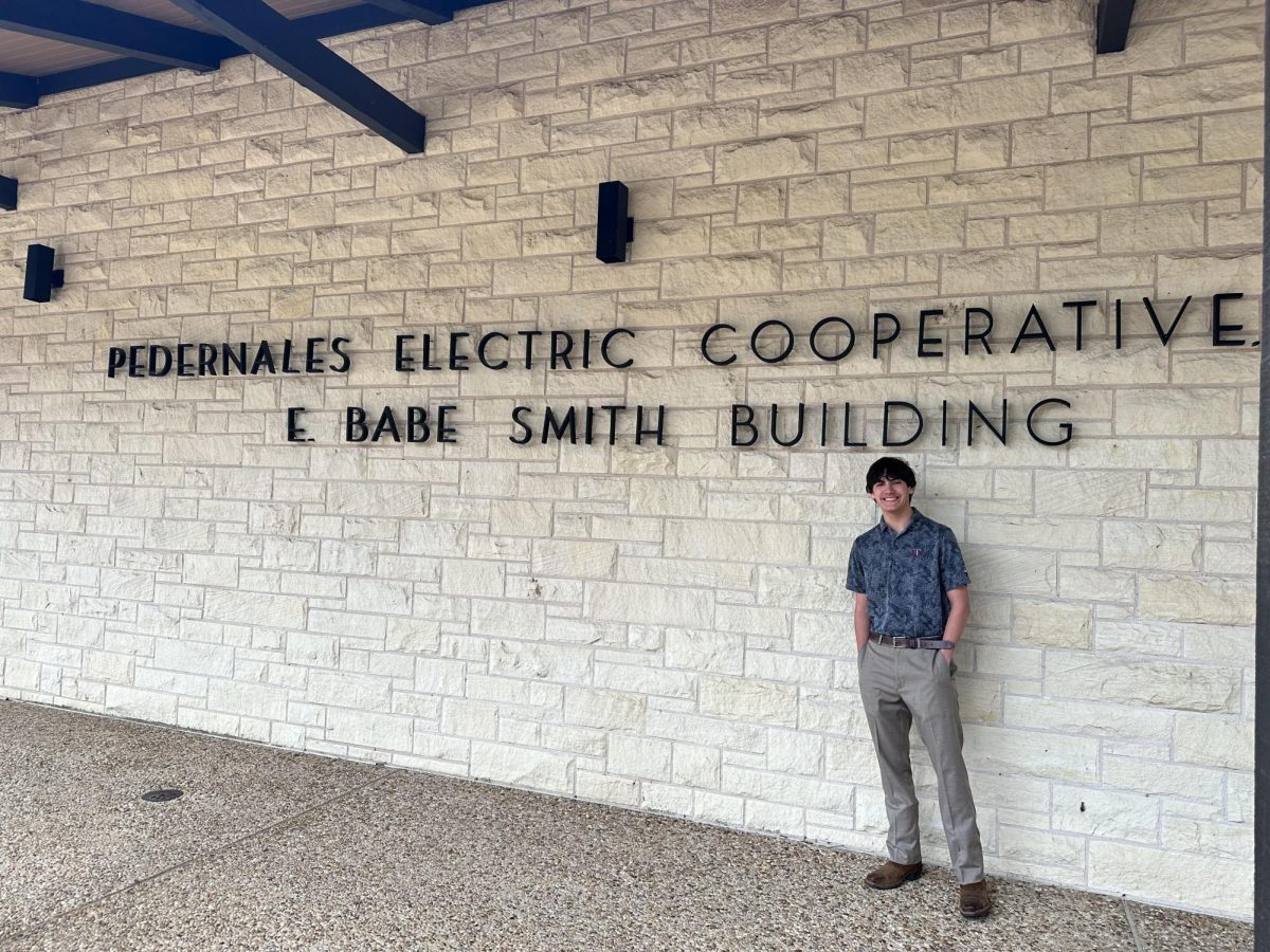 Senior Jake McAnelly poses in front of the Pedernales Electric Cooperative building after finding out he was selected for the Youth Tour. Photo courtesy of Jessica McAnelly.