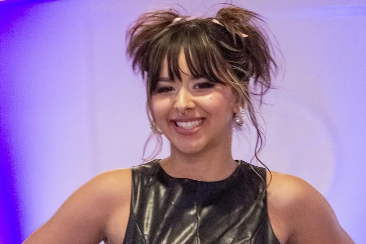 With a stylish hairdo, senior Elyssa Gomez smiles when posing at the end of the runway