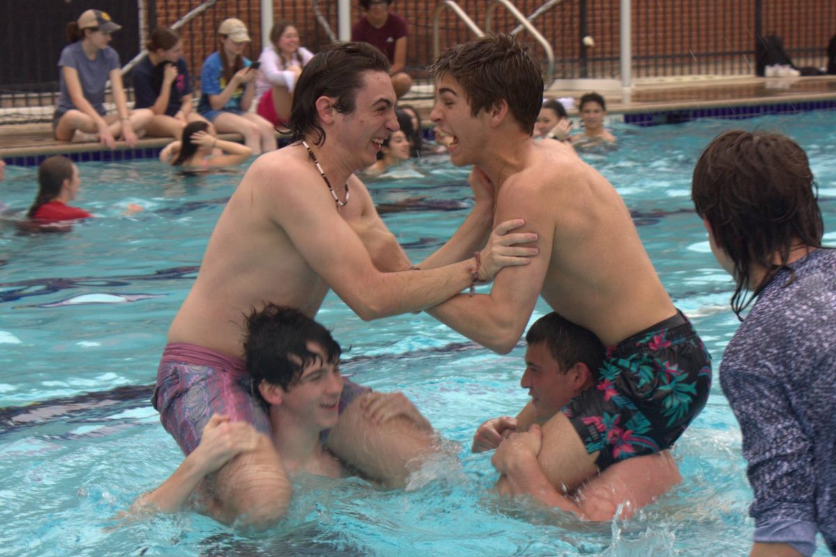Juniors Alec Suarez and Hudson Patteson wrestle each other in the pool after completing the boat races. Both students made it across the pool without sinking.