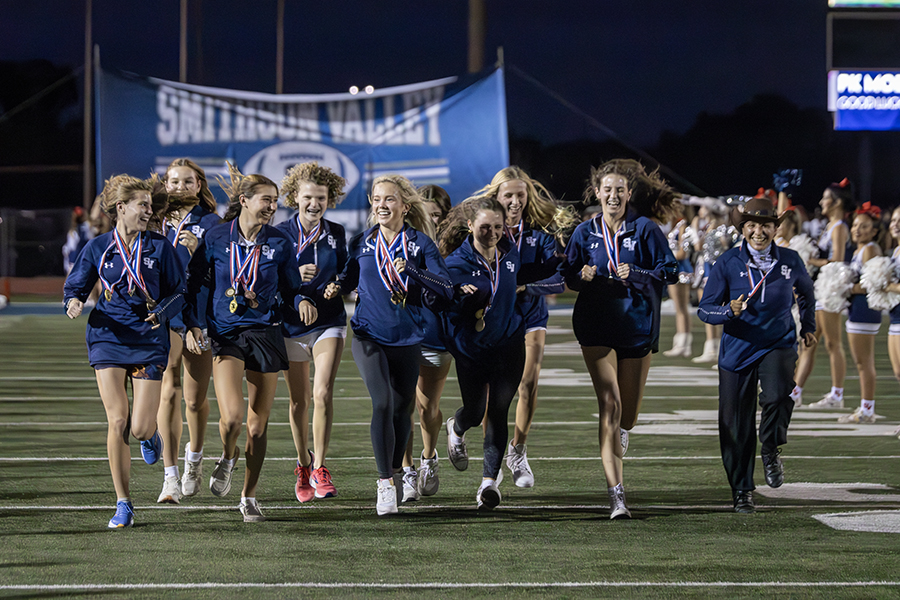 Members of the state-bound cross country team get their run through the banner during the first Rally in the Valley Wednesday at Ranger Stadium. The girls compete at the state meet Saturday.