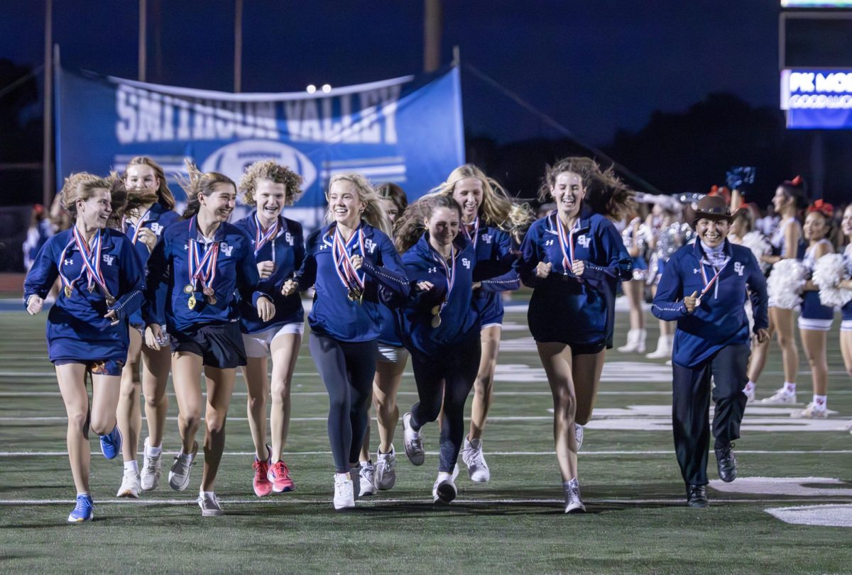 Members of the state-bound cross country team get their run through the banner during the first Rally in the Valley Wednesday at Ranger Stadium. 