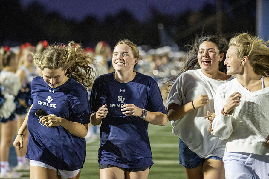 Members of the swim and dive team also run down the field.