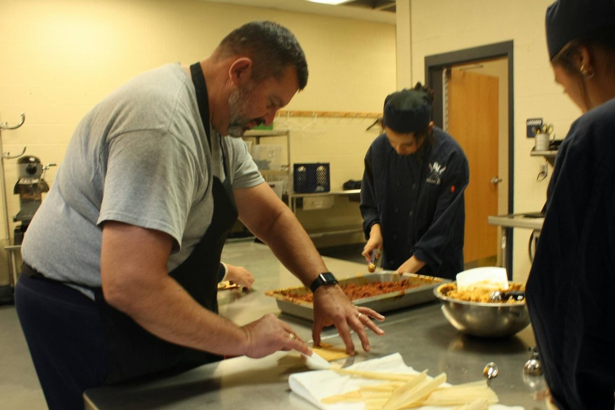 Athletic trainor Brian Zettler works to make his own tamale with the culinary students.