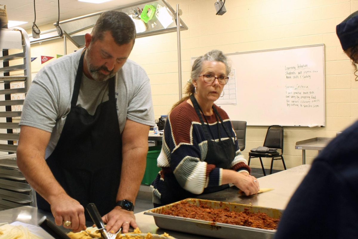 Athletic trainor Brian Zettler and student support specialist Hope Zettler work together to make tamales. 