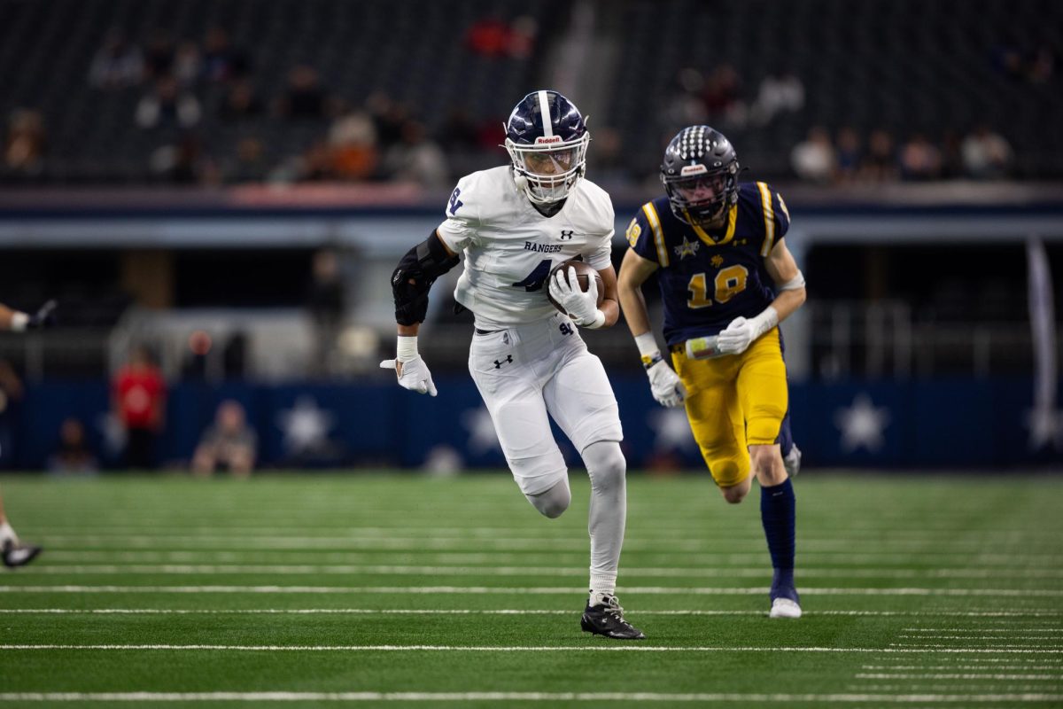 Senior Julian Colugna runs down field with the ball to score a touchdown after intercepting the ball.